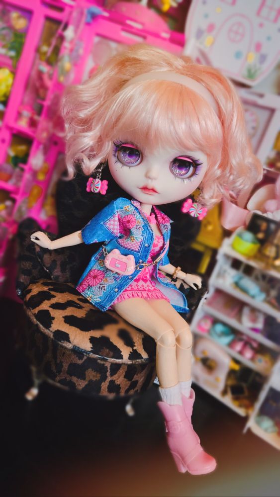 The doll posed braced in the chair and looking at the camera