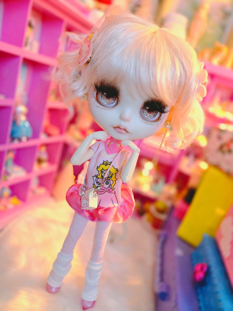 The doll posed with her hands under her chin