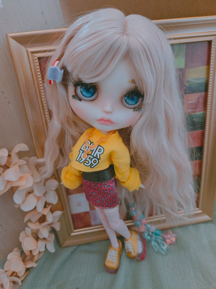 My doll Everleigh with crimped hair wearing a yellow sweater, pink mini skirt, and tall yellow sneakers