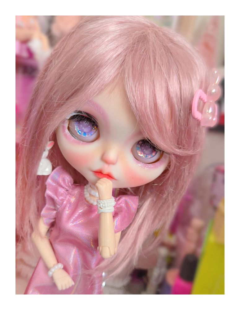 The doll with her hand by her mouth 