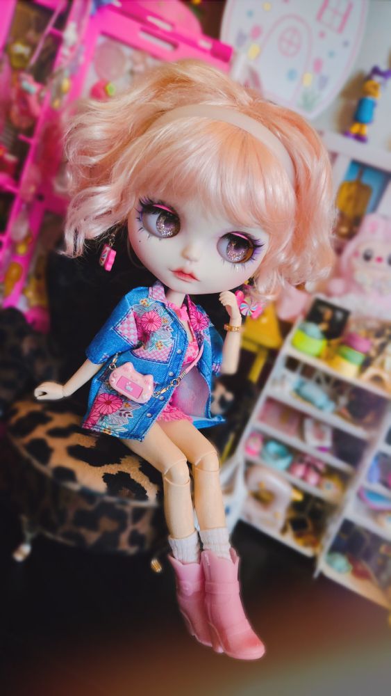 The doll looking right and leaning her cheek into her hand