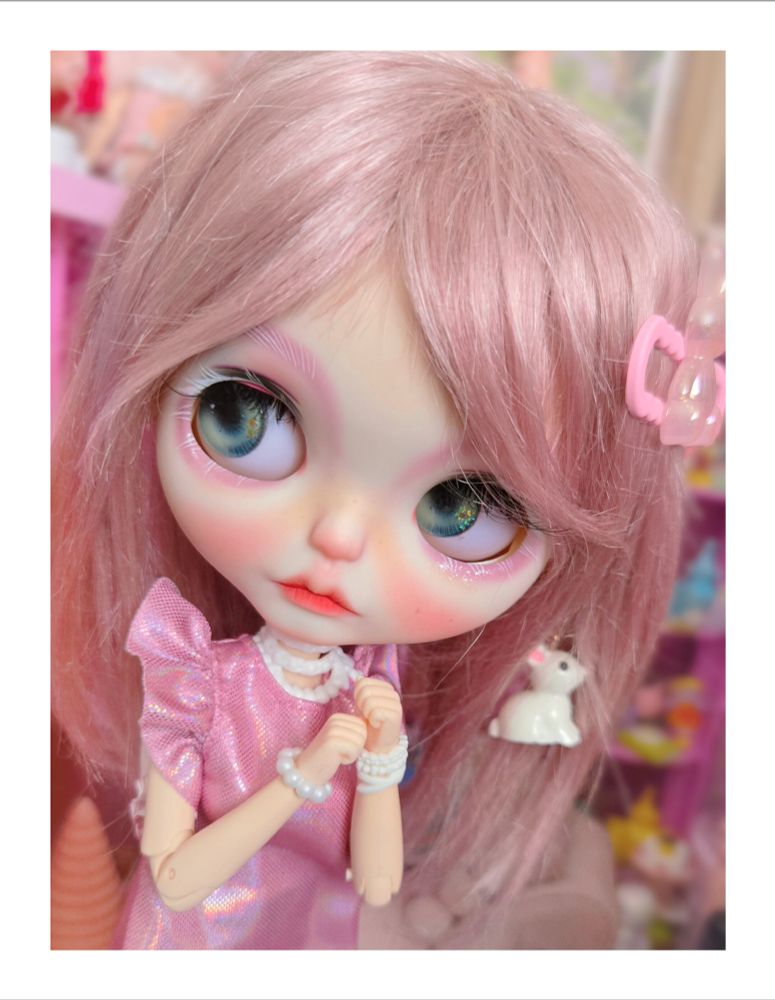 The doll looking left with green eyes, holding her hands together 