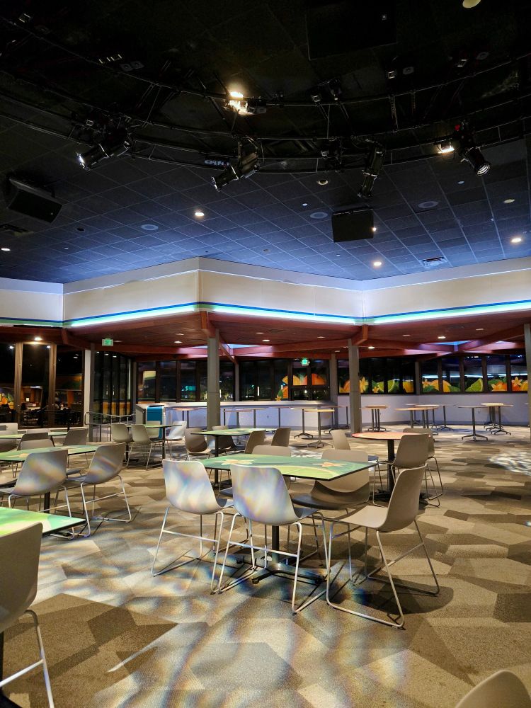 An empty cafeteria space lit up by rotating blue lights
