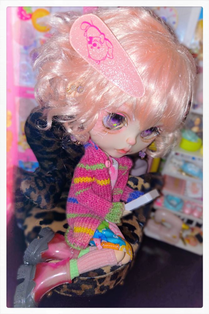 The doll looking down at her phone and reading intently 