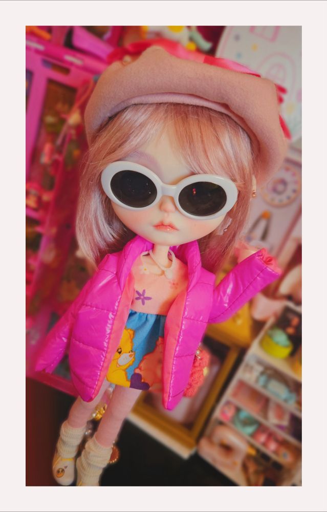 Full-body photo of the doll with her arm raised 