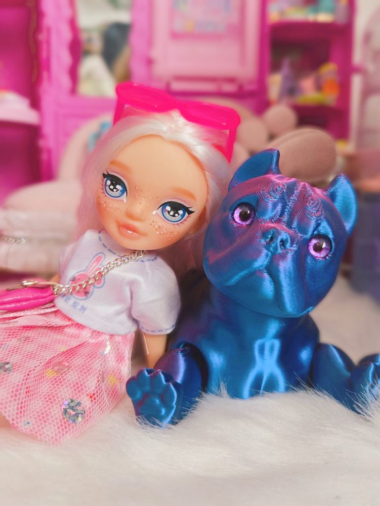 The doll and the dog sitting on the floor together posing for the camera 