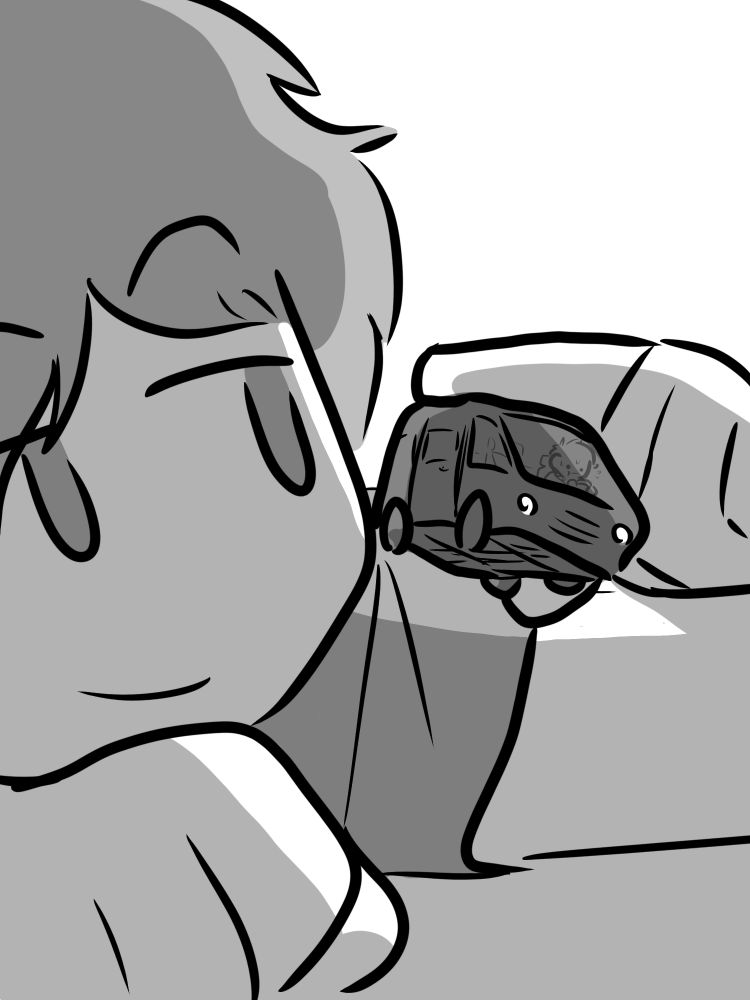 boy holding a car. there is someone in the car.