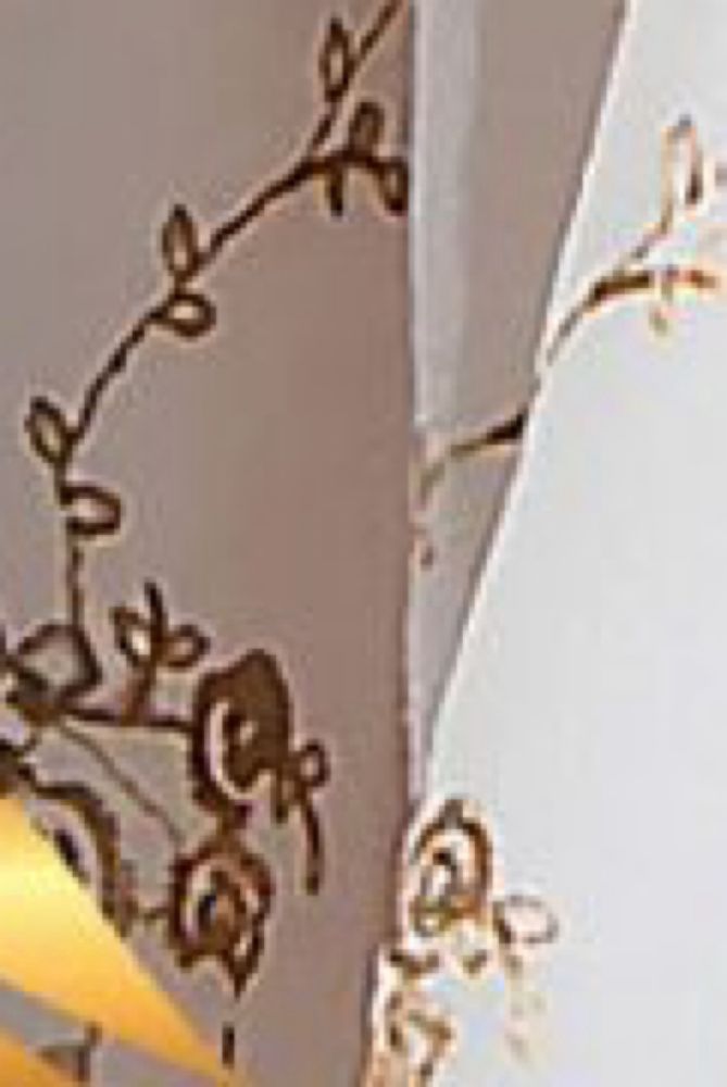 Close up of the dressing showing the embellishment on the fabric that looks like a messy incomplete mash up of flowers, vines, and bows. 