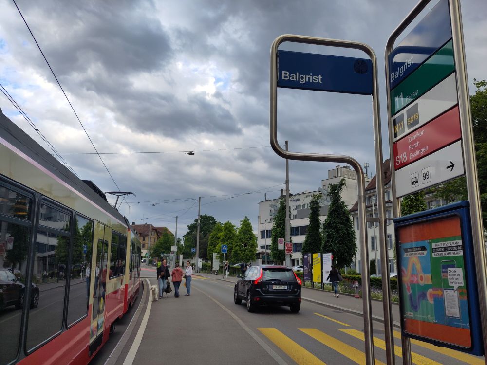 Tram at the platform of Balgrist station. The station sign lists lines 11, N11, SN18, S18, and 99.