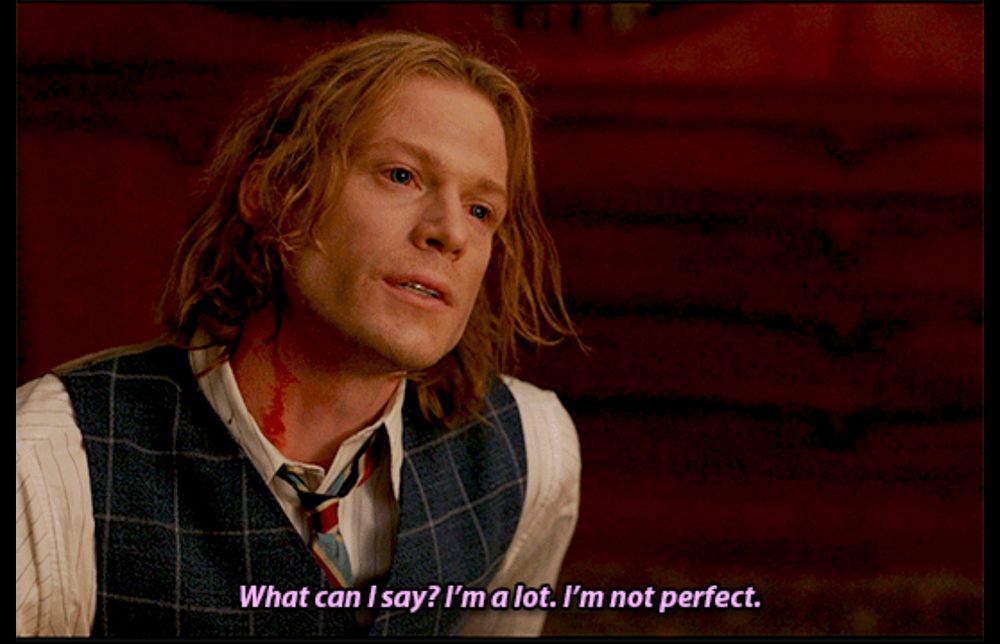 picture of Lestat from Interview with a Vampire looking disheveled and intense in his nice shirt, vest and tie, with blood dripping down his neck. caption reads: “what can i say? i’m a lot. i’m not perfect”  