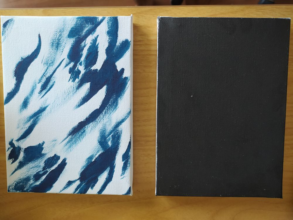 Deux peintures petite format une toute noire à droite et à gauche une avec des formes éthérés bleus