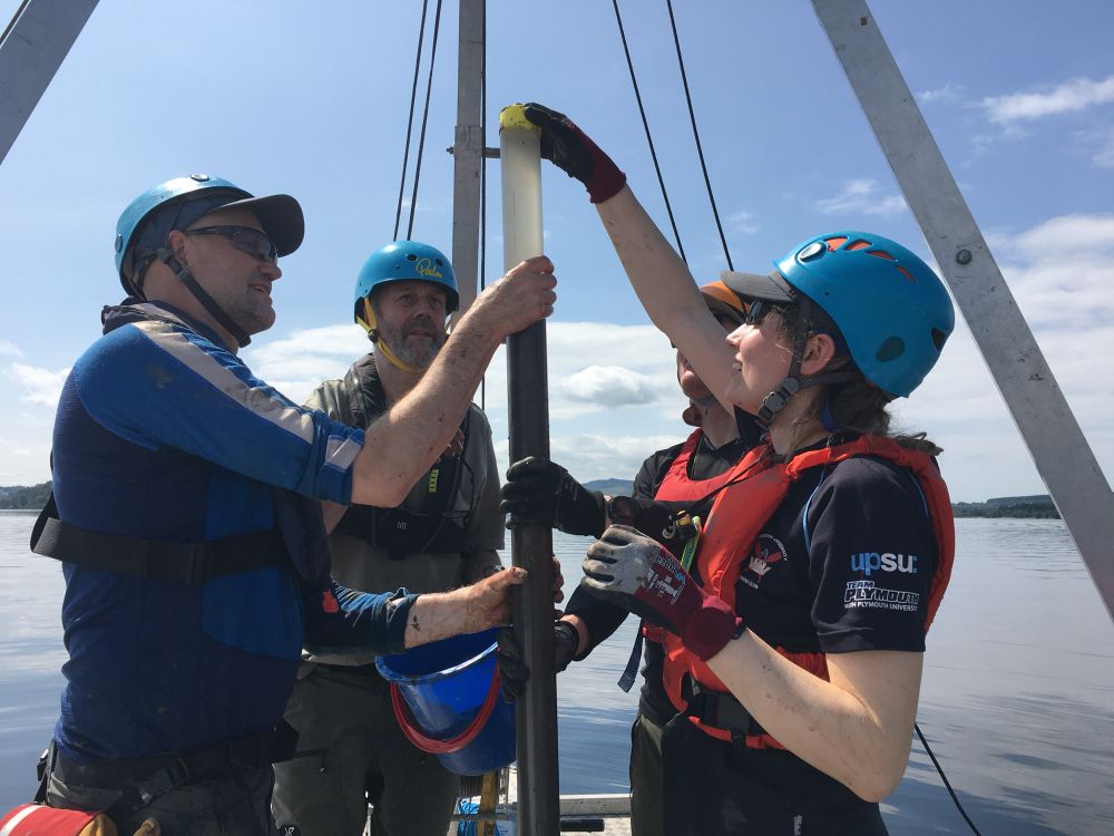 Collecting cores in the middle of Loch Lomond - 4 people capping a surface core retrieved for potential fish eDNA analysis 