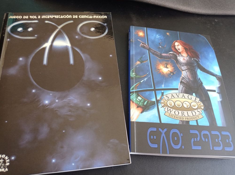 Foto con las portadas de dos libros. El de la izquierda es un fondo espacial bajo las palabras «EXO, juego de rol e interpretación de ciencia ficción», tiene el logo de Ediciones Sombra (la silueta de un Detective Noir con las palabras Ediciones Sombra rodeándolo). La portada del libro de la derecha es una mujer soldado de ciencia ficción dando una orden desde un puente de mando de una nave. De fondo puede verse una batalla entre cazas espaciales. El título es «EXO 2933» y tiene el logo de «Savage Worlds Licensed Product». 