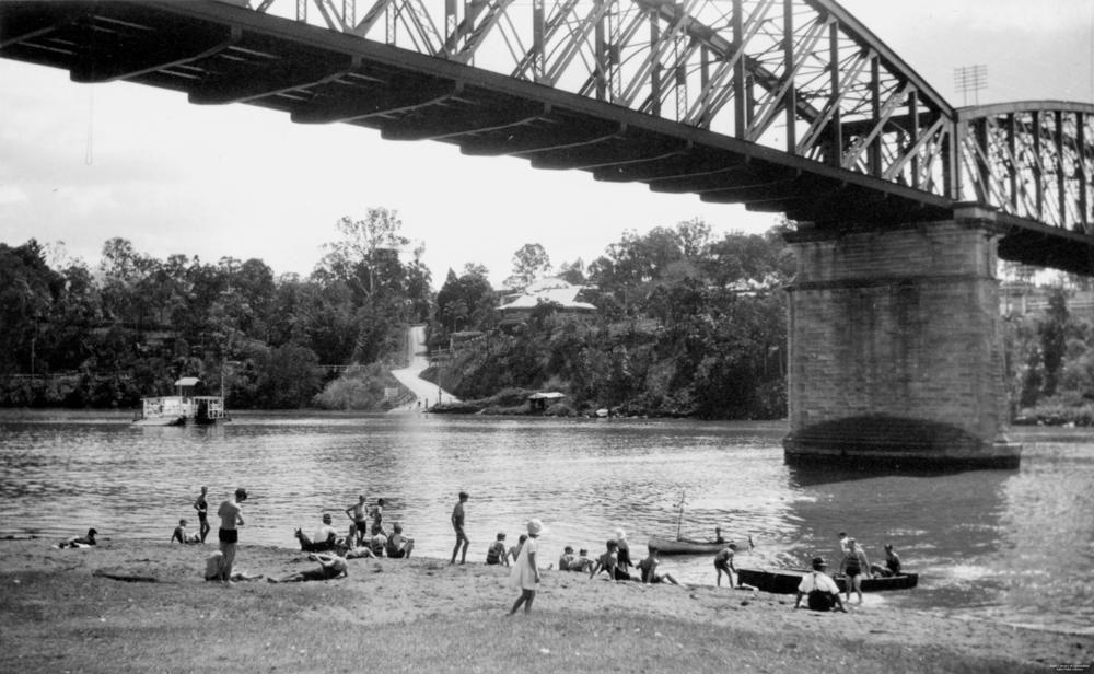 A dozen or so people swimming and mucking about in boats under the Indooroopilly rail bridge. There’s two more bridges in that spot today. 