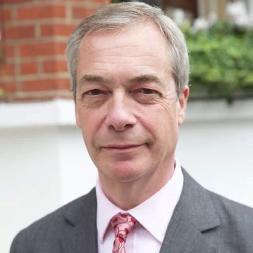 a man wearing a suit and tie is smiling for the camera