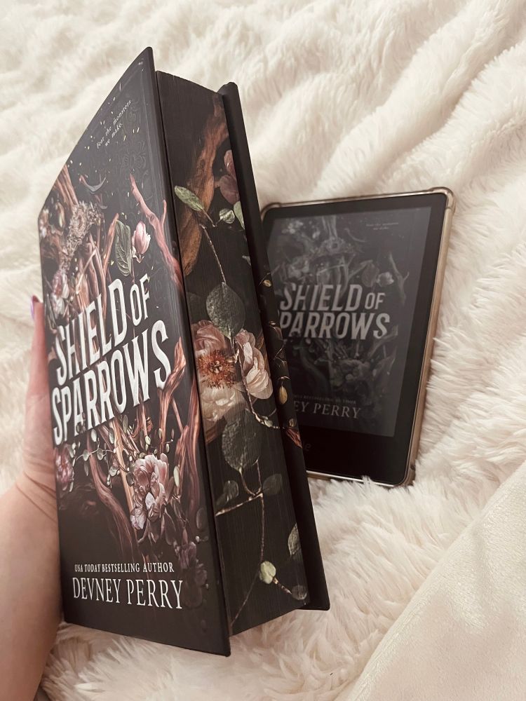Showing the side of Shield of Sparrows by Devney Perry: sprayed edges with floral design & kindle showing the book’s front cover