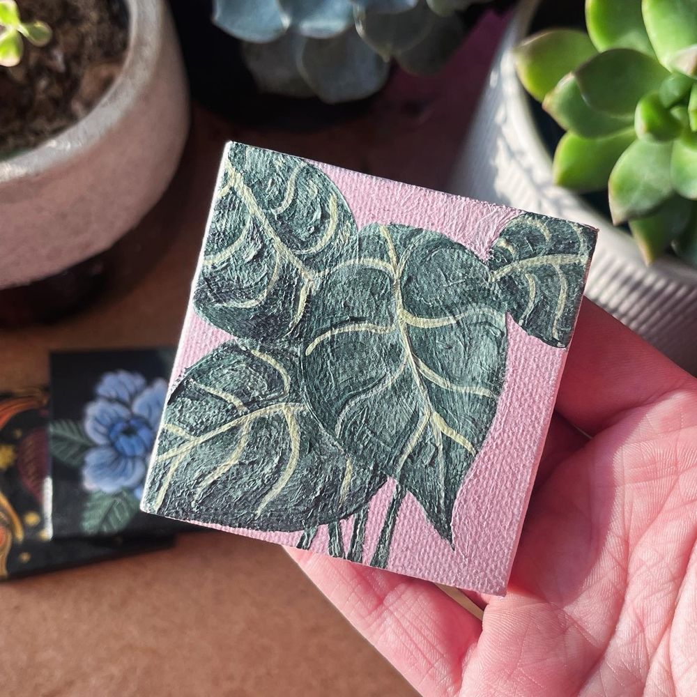 a mini painting of alocasia leaves on a light pink background 