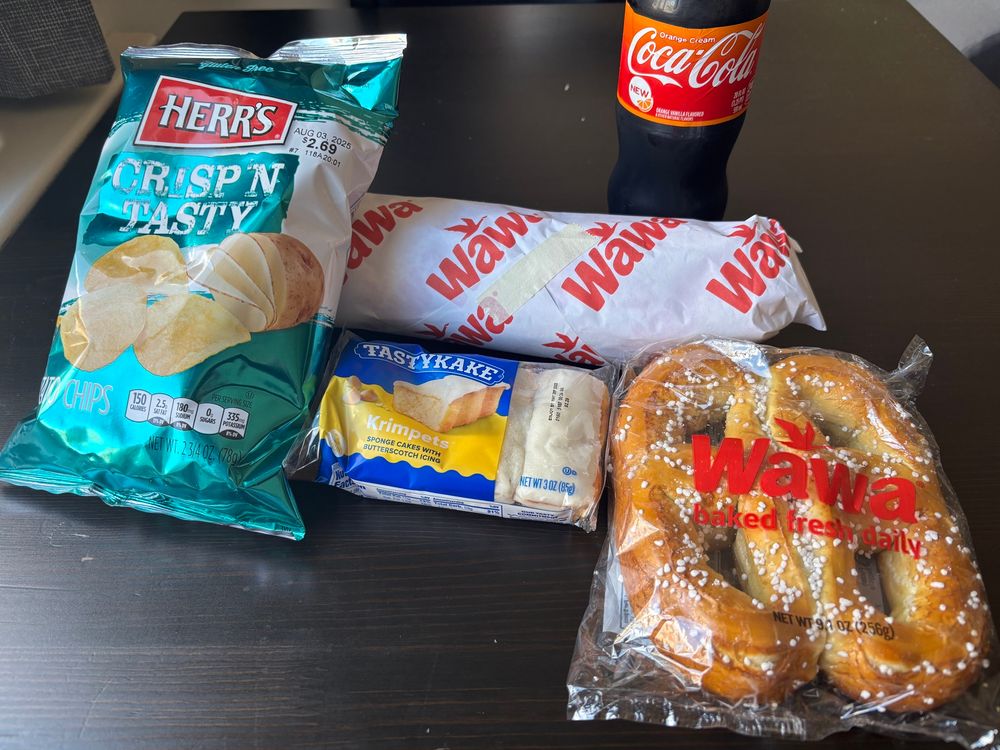 a wawa hoagie with herr’s chips, wawa soft pretzels, tastykake butterscotch krimpets, and an orange vanilla coke 