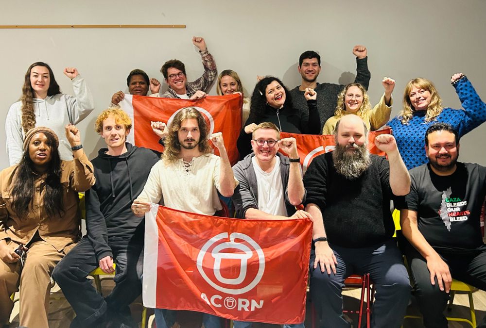 Group photo of me and the rest of the ACORN board. Smiles, raised fists & red flags abound.