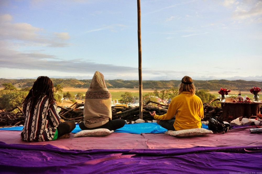 Group of students, high on lsd, meditate at a music festival. 