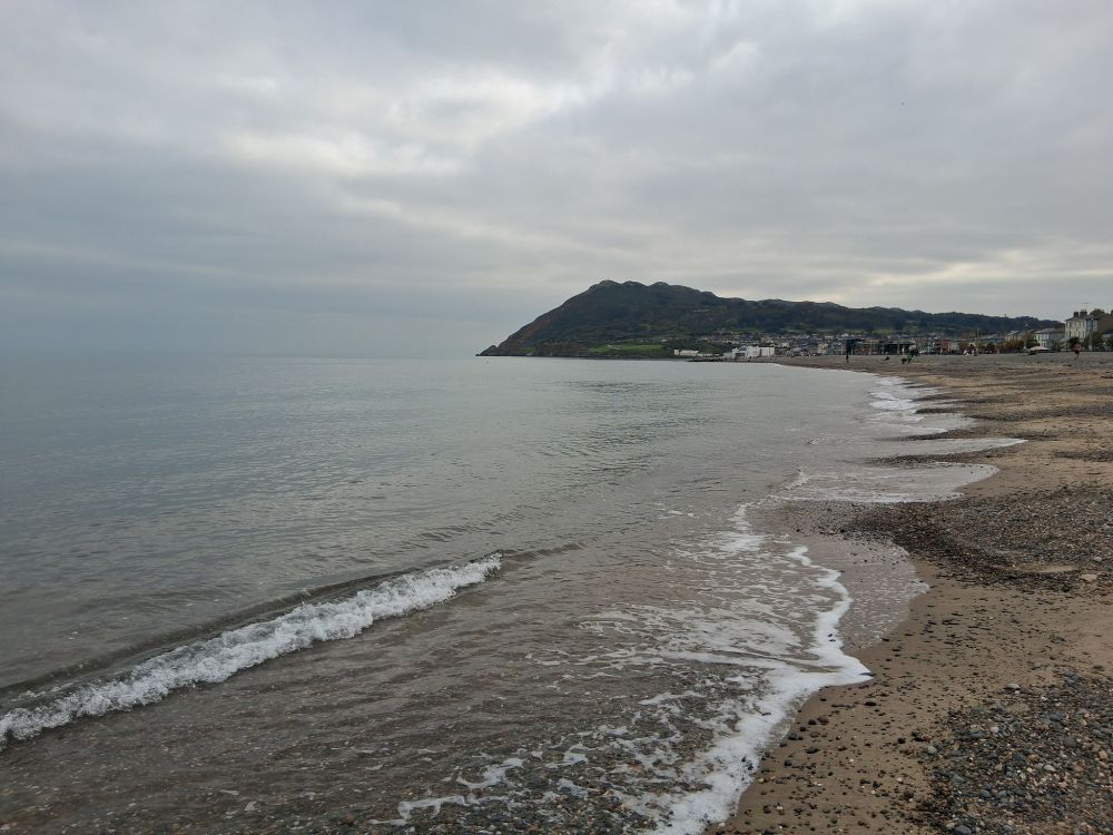 A look down a sea coast, with a large headland in the distance.