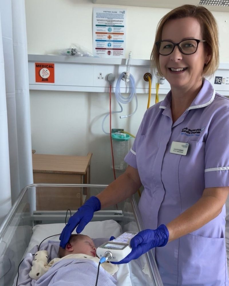 One of the team carrying out a hearing check on a baby