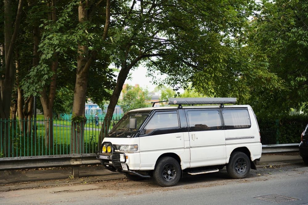 An offroad camper parked in front of a park