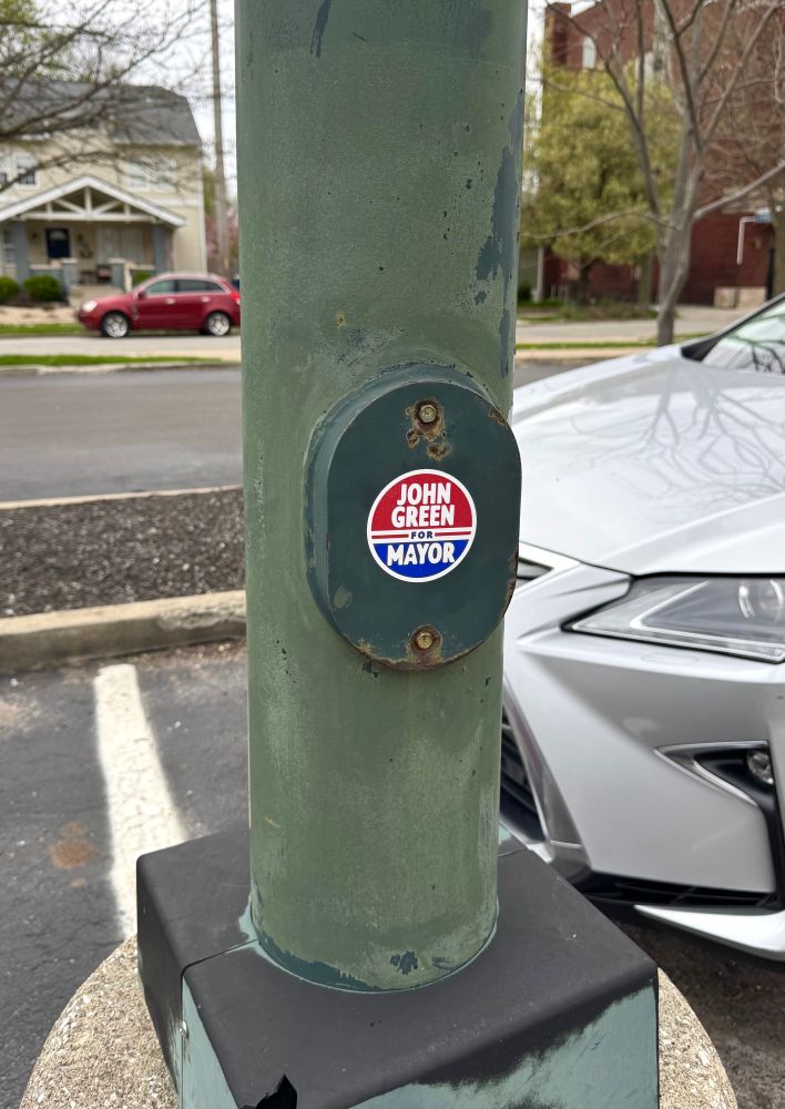 “John Green for Mayor” sticker on a light pole.