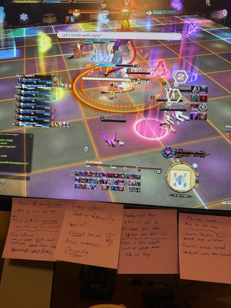 picture of a monitor depicting tiled floor with “dead” ff14 players and sticky notes of mechanics on said monitor