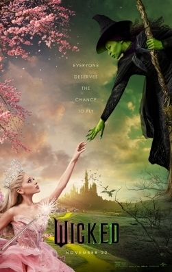 Film poster for Wicked the movie. With the young Elphaba the Wicked Witch of the West floating on a broom reaching out to her school friend Glinda the Good Witch