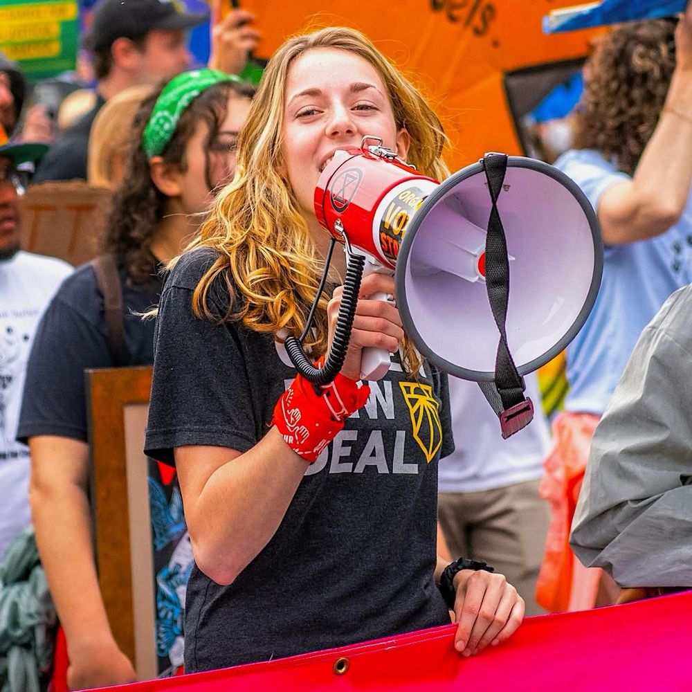 Girl in crowd speaking through a megaphone 
