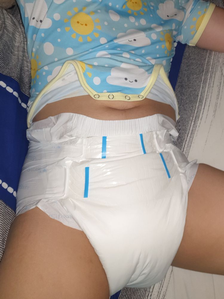 That lioxy kiddo in an opened onesie and a white diaper