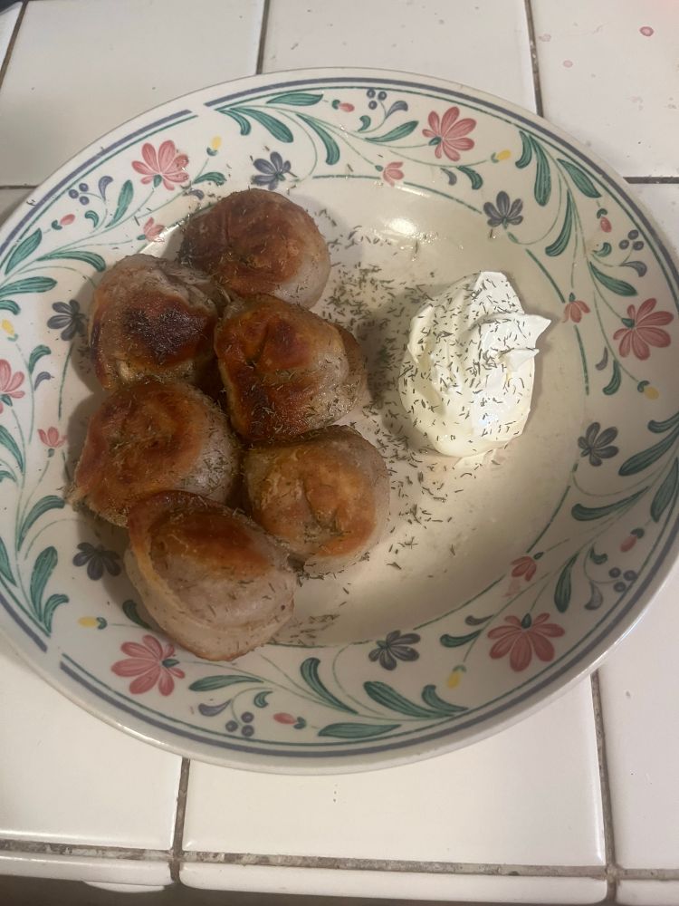 6 pelmeni have been fried and are now served with smetana and dill. pelmeni are a dumpling which is saturn shaped, since this is where they originate according to a special I saw on ren tv 
