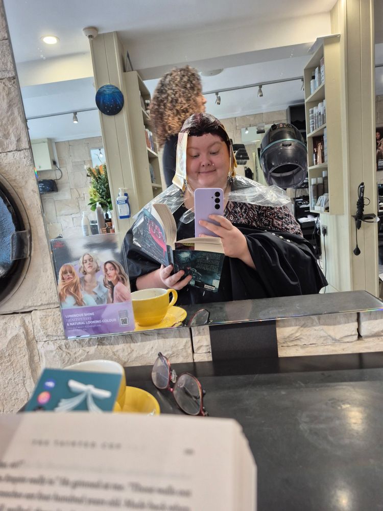 Leagh's hair is covered in hair dye and she has a book in her hand