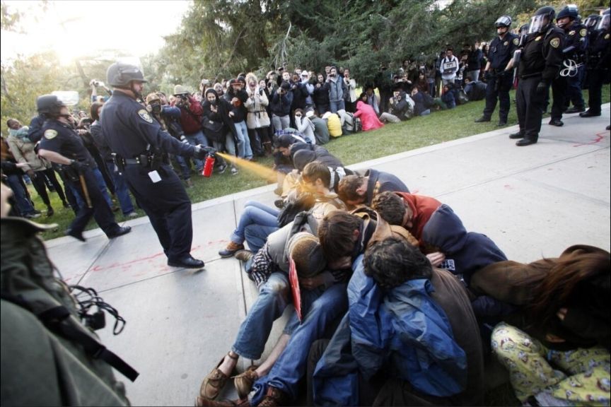 Peaceful, seated students at a UC Davis sit-in protest being hosed with pepper spray from two feet away by an oafish cop in riot gear