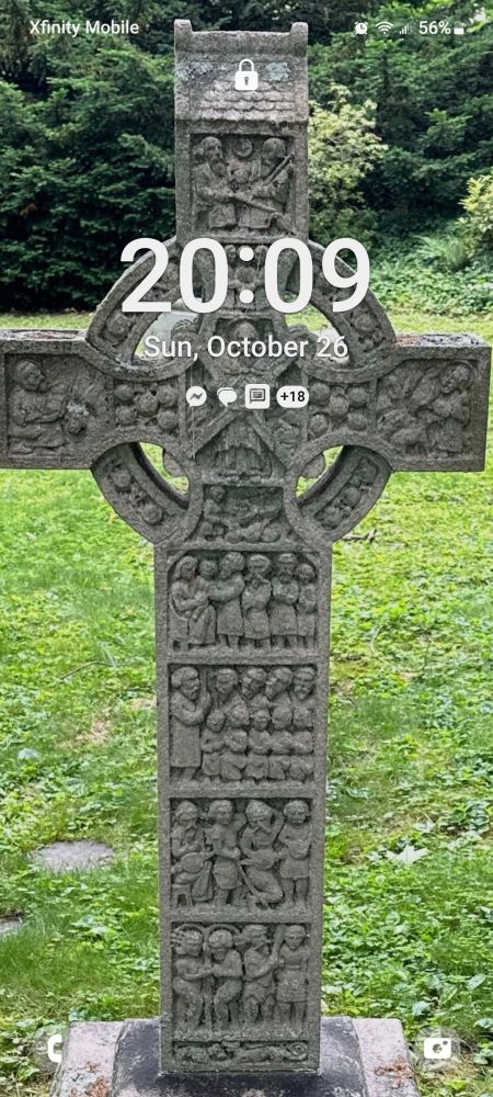 A gravestone in the firm of a Celtic cross in a cemetery in Massachusetts, with the time of day superimposed over it 
