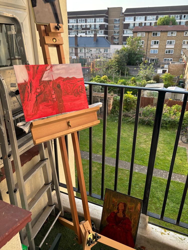 Two paintings on an easel on a balcony