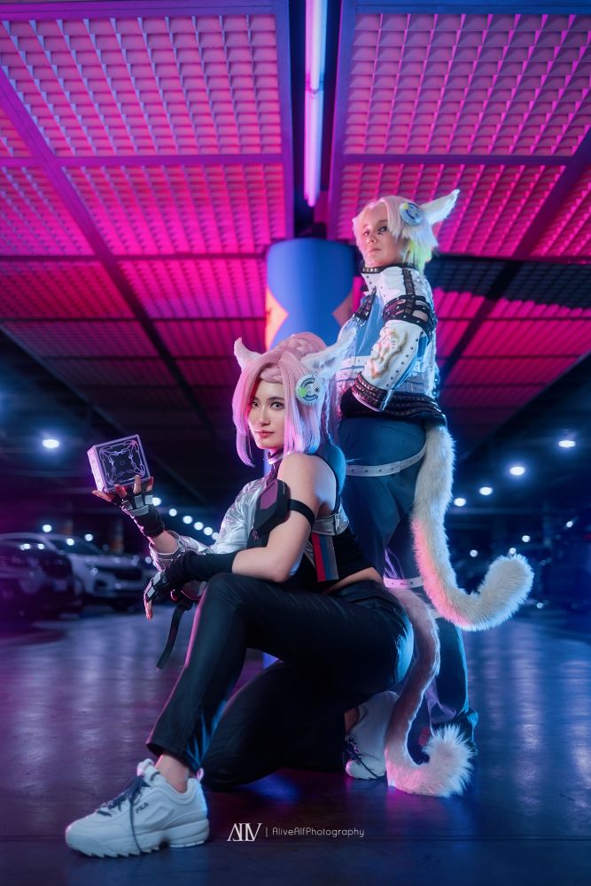 Wicked Thunder cosplayer crouching in front of a Howling Blade cosplayer standing looking back towards camera
