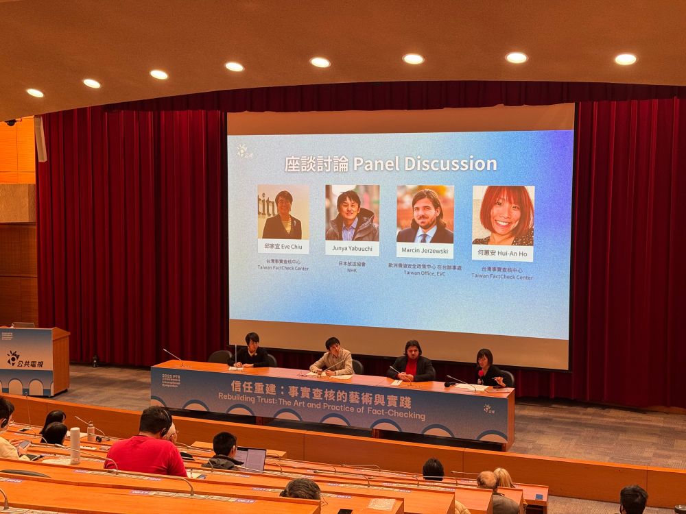 Photo of panelists and moderator sitting on stage in front of screen slide listing their names and photo headshots.