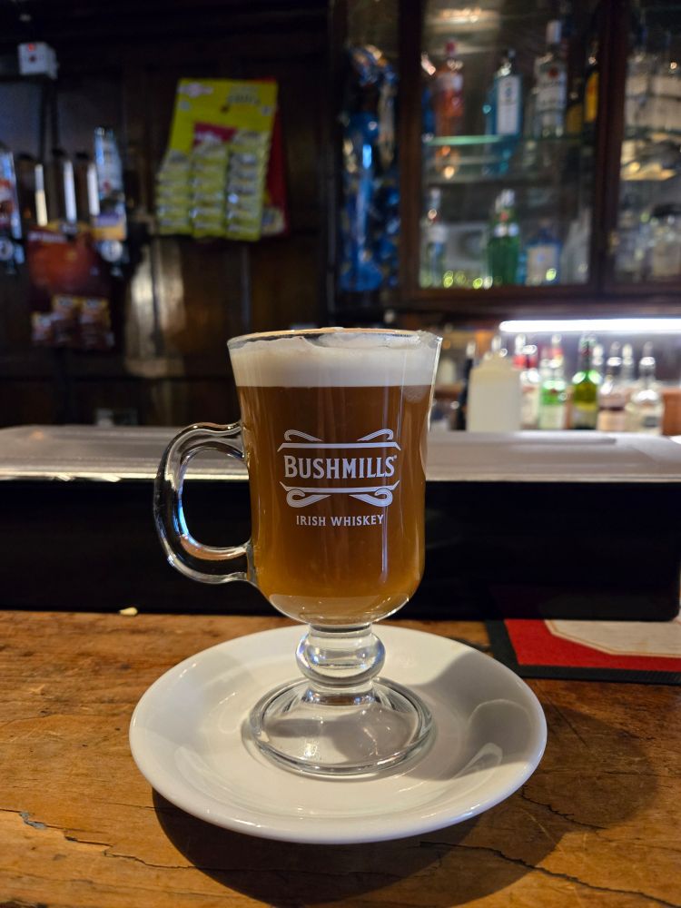 An Irish coffee in a Bushmills glass mug in a pub in Dublim