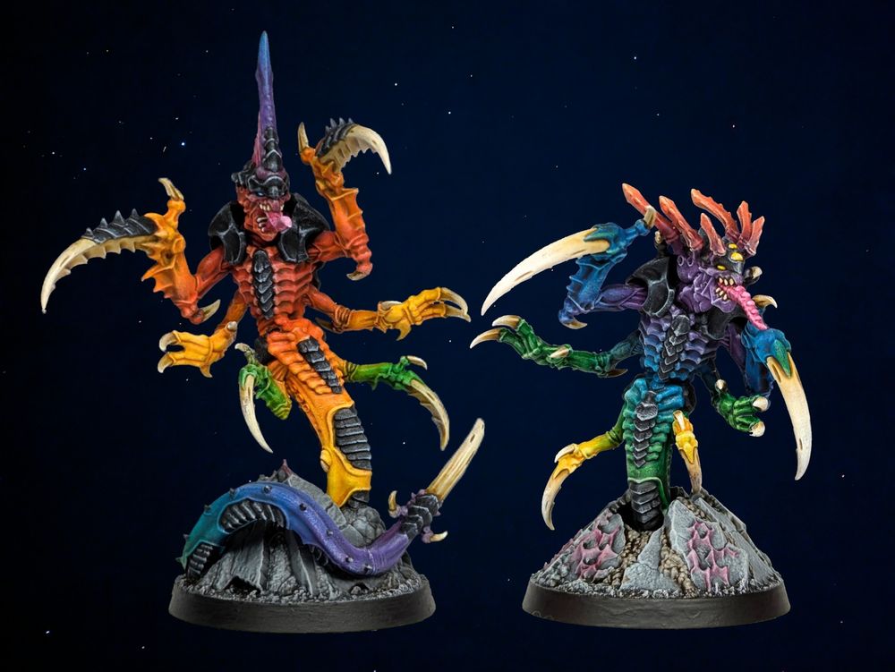 Two Tyranid Raveners painted in blended rainbow colours with black carapace against a dark background with stars.