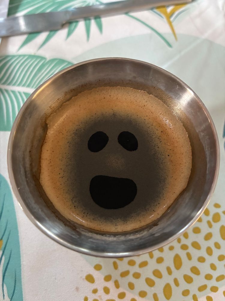 Des yeux dans la mousse du café lui donnent un air heureux
