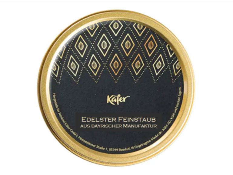 Eine Konfektdose von Feinkost-Käfer. Aufschrift "Edelster Feinstaub aus bayrischer Manufaktur".