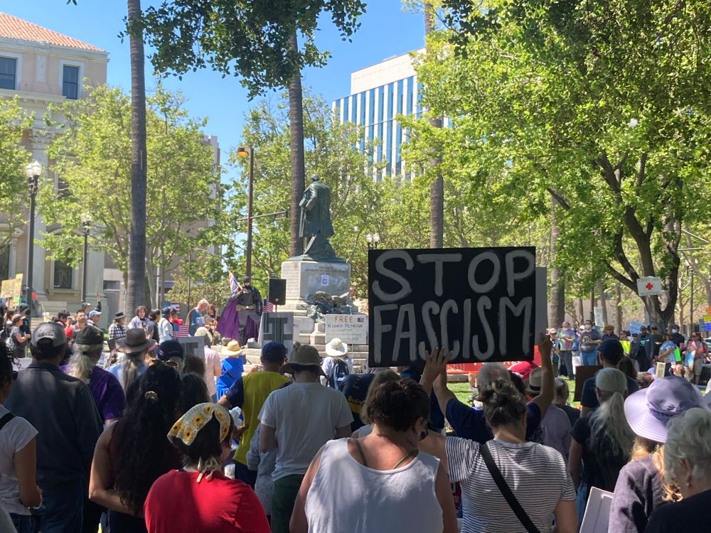 Protesters in St. James Park with a sign that says “stop fascism”