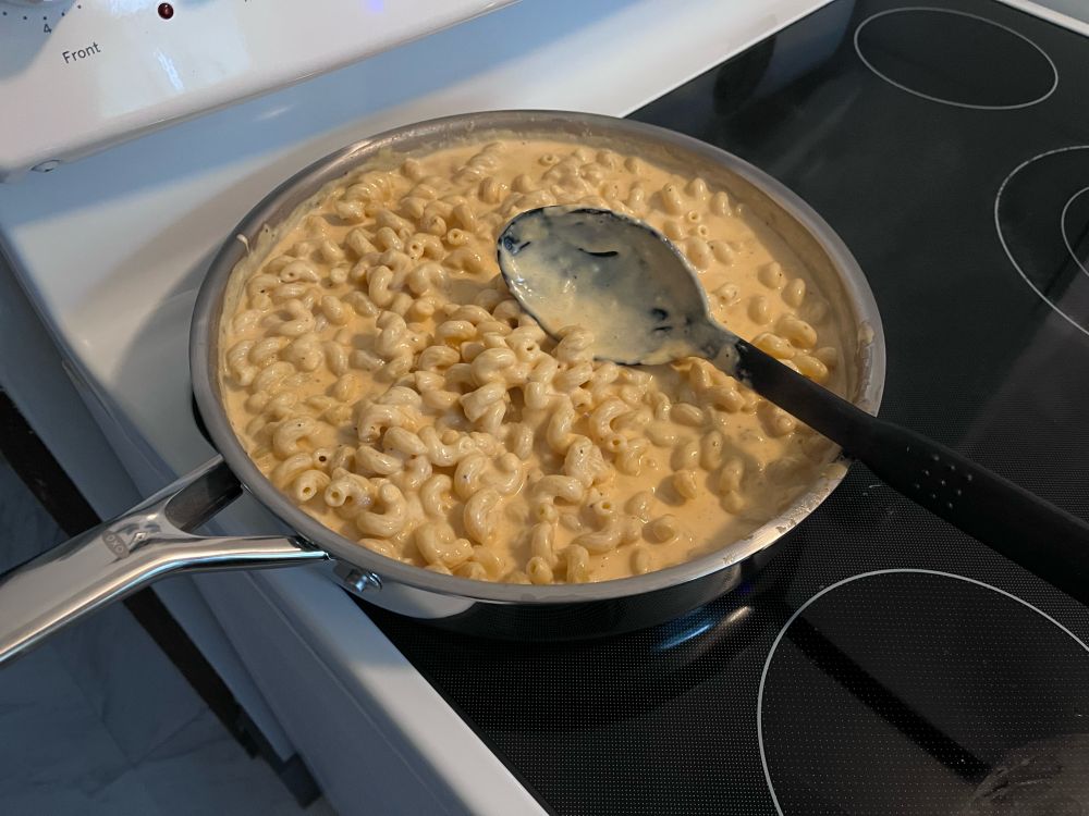 Pan on the stovetop with macaroni and cheese. 