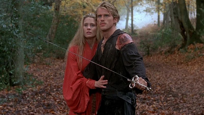 Wesley and the Princess from Princess Bride, waking together in the forest. Wesley’s sword is drawn and Buttercup clings to him as they approach the forest with rodents of unusual size.