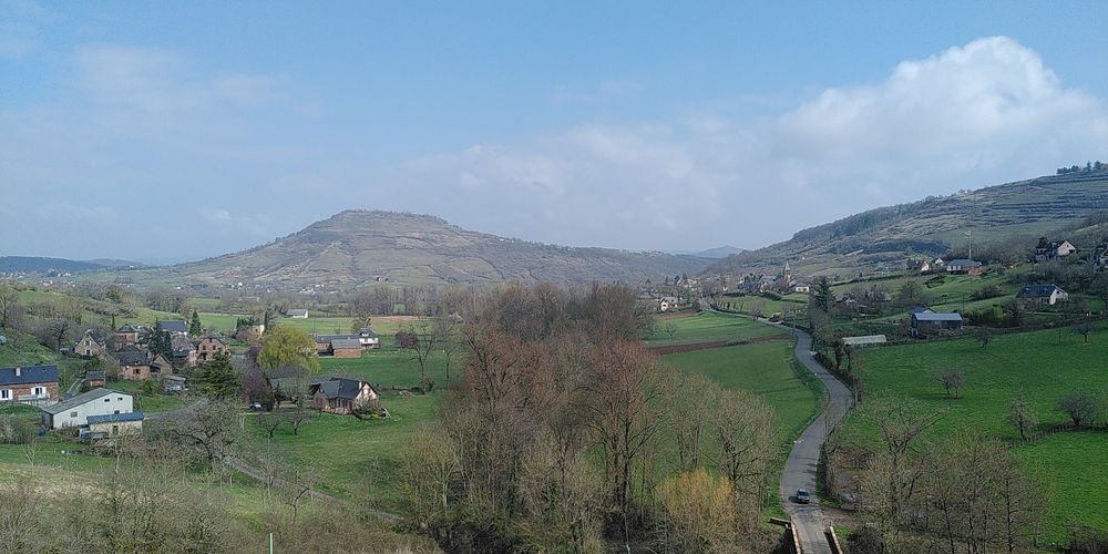 View from the train from Rodez, across the river valley with hills and town in the distance