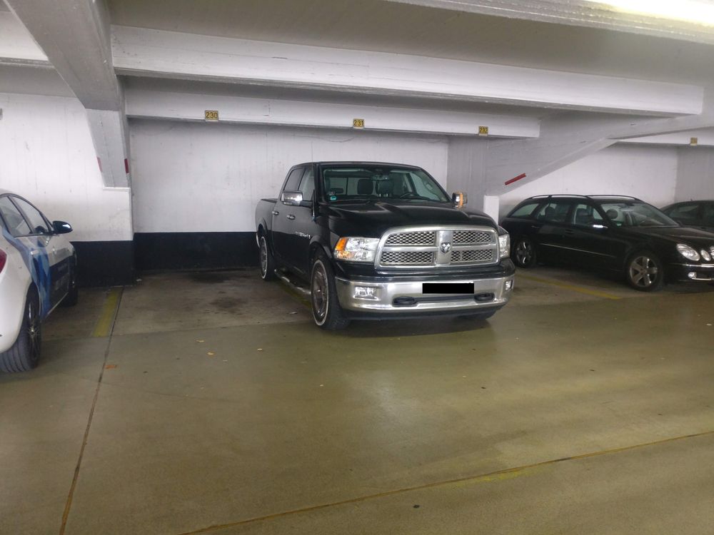 Ein großer Pick Up Truck steht in der Mitte von drei Parkplätzen. Rechts und links ist nur sehr wenig Platz