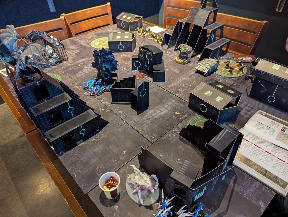 Post-Deployment setup of a 40K match. An angular view of the entire table shows the cardboard pop up terrain in use. 