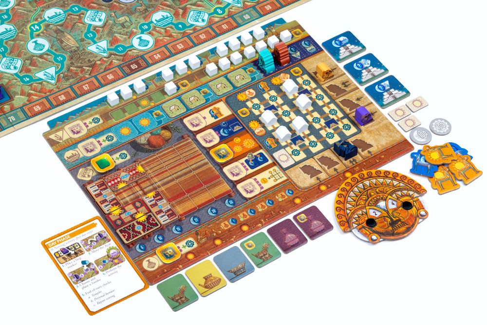 A close-up photo of a player board next to the main game board in Ayar, surrounded with reference cards, a score tracker and various cardboard tokens, and split into different sections with all sorts of wooden meeple placed around it.